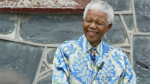 Former South African president Nelson Mandela is seen in a blue floral print shirt as he speaks at an event