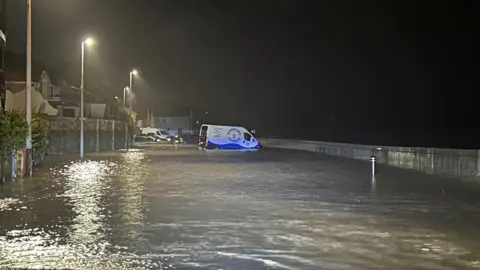 Folkestone and Hythe District Council Cars and van seen floating in completely flooded road.