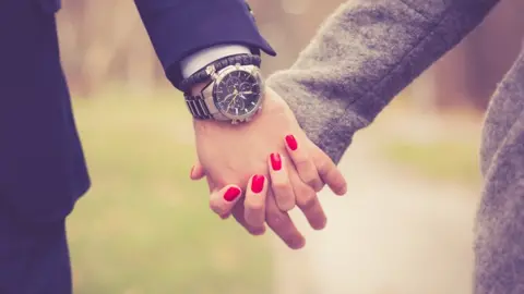 Getty Images Couple hold hands