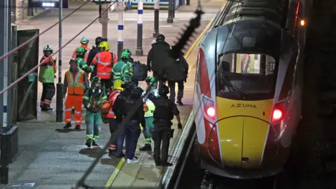 PA Media Emergency responders on a train platform in Huntingdon after reports of a stabbing on a LNER train. 