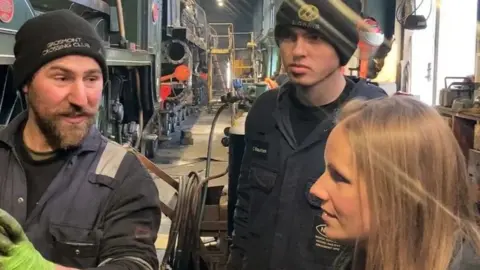 Jim Addyman/BBC Charlie Bauckham and Aleisha Bell in front of steam locomotive