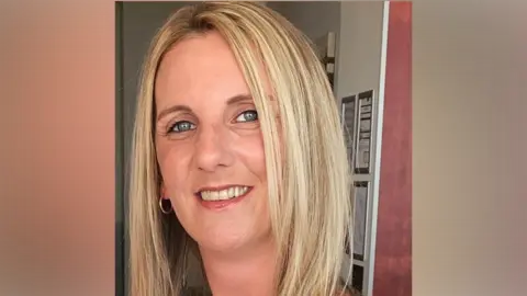 Carly Hicks has blonde hair and is smiling.
