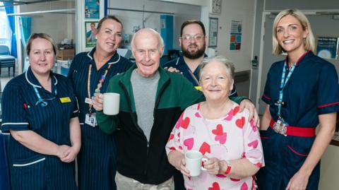 Hospital staff with a patient and their partner