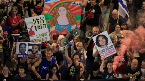 Reuters protesters attending a demonstration to show support for the hostages taken in the deadly October 7 attack held up banners with pictures of loved ones and lit flares.