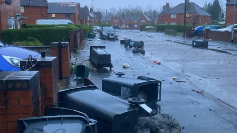 Carol Williams Bins and debris in the road