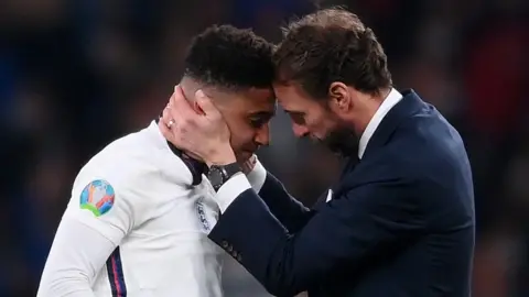 Getty Images England manager Gareth Southgate consoles Jadon Sancho