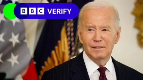 Getty Images Joe Biden berbicara kepada wartawan di Gedung Putih. Bendera Amerika terlihat di latar belakang, dan logo Verifikasi BBC dipasang di atas gambar. 