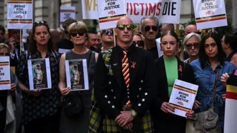 Getty Images Protesters holding placards with messages related to the NHS infected blood scandal