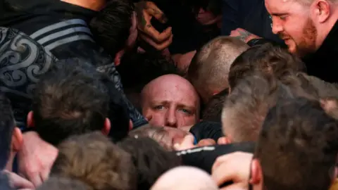 Reuters Man in middle of the scrum