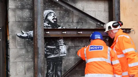 Wales News Service Contractors inspect the Banksy