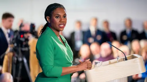 Conservative party leader Kemi Badenoch addresses the Scottish Conservative party conference at Murrayfield Stadium, wearing a green long-sleeved dress.