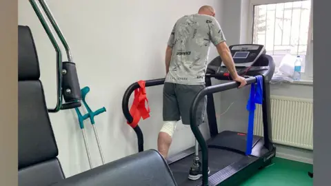 Tove Benefice/Steve Challen Ukrainian veteran with leg prosthetic on treadmill at rehabilitation centre, Ukrain 