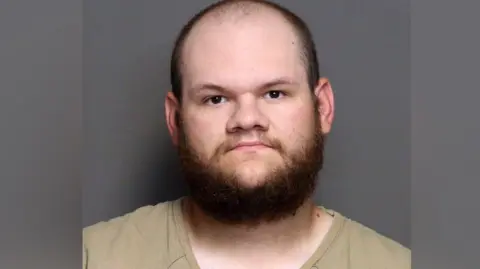 Franklin County Jail Mugshot pic showing Tycen Proper who is bearded with brown/red hair and he is looking down the barrel of the lens, dressed in khaki prison clothing