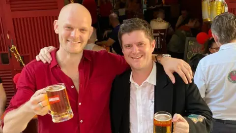 BBC Luke Jones and Ross Clarke holding a beer