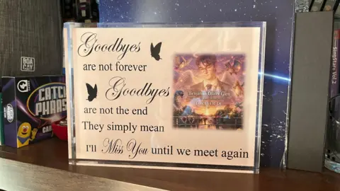 An ornament with a picture of Ben Glen on it. It says Goodbyes are not forever. Goodbyes are not the end. They simply mean I'll miss you until we meet again.