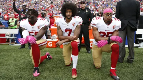 Getty Images Kaepernick kneels in protest with two former teammates