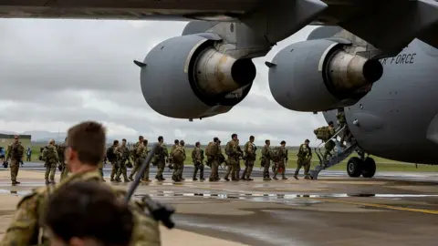 AUSTRALIAN DEFENCE FORCE Australian soldiers queue to get on board a military aircraft headed to Solomon Islands