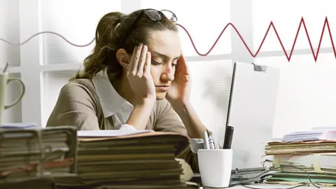 Thinkstock and BBC A female worker looking stressed