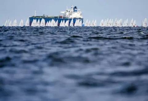 Sem Van Der Wal / AFP Dinghies pass in front of a tanker