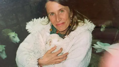 Sarah Thomas Claire holding a lamb