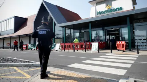 Getty Images A police officer in Hampshire outside Morrisons