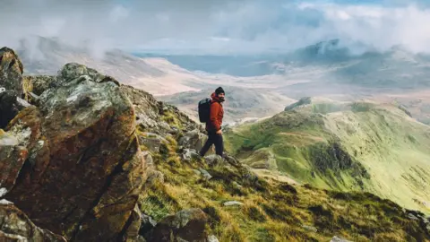 Getty Images A hiker wearing a backpack, making his way down from the summit of Snowdon on a beautiful autumn day