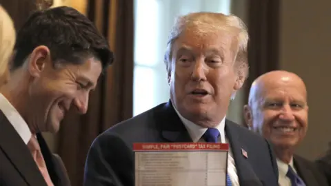 Reuters Trump holds up "postcard" taxes