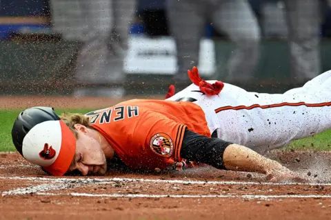 Tommy Gilligan / USA Today / Reuters Baltimore Orioles third baseman Gunnar Henderson slides into the home plate to score a run at Oriole Park at Camden Yards, Baltimore