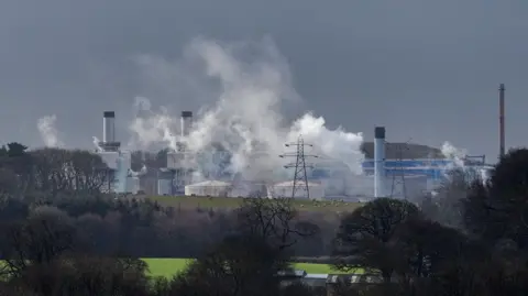 A general view of the Sellafield site seen from a distance, with vapour coming out of some of the chimneys.