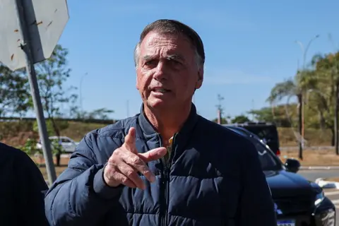 Brazil's former President Jair Bolsonaro gestures as he arrives to the State Secretariat of Penitentiary Administration headquarters in Brasilia, Brazil 