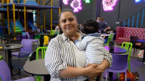 Woman holding a baby in a play centre