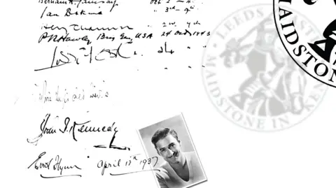 Trustees of the Leeds Castle Foundation A close-up of a page from a visitor book showing handwritten signatures and notes in black ink, including a bold signature reading “John F Kennedy”. A faint stamp reading “Leeds Castle Foundation” is visible, along with a small black-and-white photograph placed on the page.