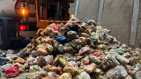Lincolnshire County Council A waste transfer station. There is a pile of bags of food waste.