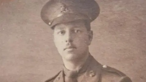 Handout A black and white photograph of 2nd Lt Noel Whittles in uniform and cap, who has a neat moustache and looks into the camera with a serious expression