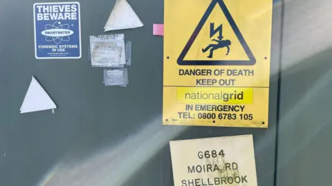 Signs on an electrical substation near a solar farm