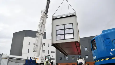 NHS Forth Valley A Portacabin modular building being taken from a lorry and put on to the grounds of NHS Forth Valley as part of plans to build the delayed inpatient ward