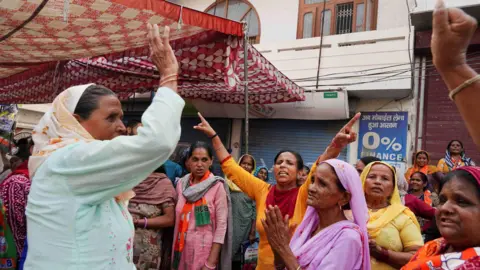 Reuters Supporters of India's ruling Bharatiya Janata Party (BJP) shout slogans outside a polling station in Karnal in the northern state of Haryana, India, on October 5, 2024. 