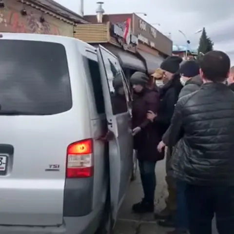 FSB A silver minibus with an open door and people standing next to it