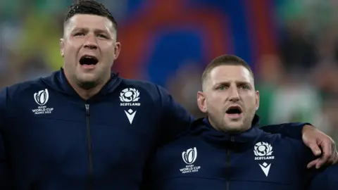 Scotland's Jamie Ritchie, Grant Gilchrist and Finn Russell sing the national anthem during a Rugby World Cup match between Ireland and Scotland at the Stade de France, on October 07, 2023, in Paris, France