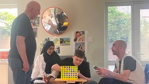 Two men and a woman sitting around a coffee table playing a game.