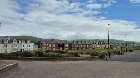 The beach and promenade at Girvan, with row of houses and B n Bs visible in the distance.
