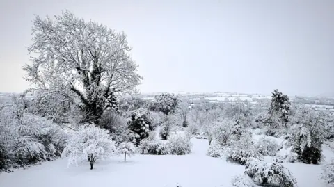 BBC Weather Watchers/David G Snow-covered fields and trees with hills covered in snow in the background