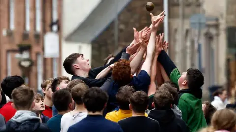 A group of young men fight over a small leather ball on the streets of Jedburgh