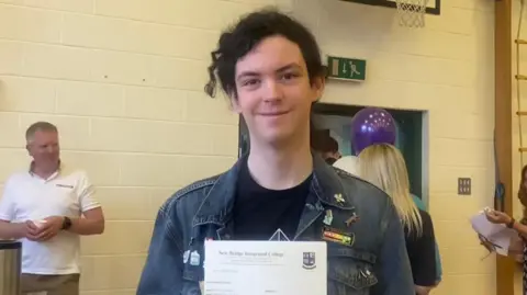 New-Bridge Integrated College student Matthew holding his results
