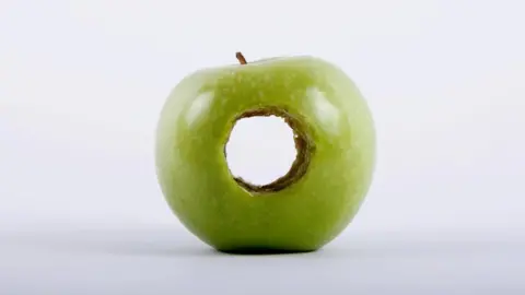 Getty Images Apple with hole in it