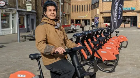 Voi A person sitting on an e-bike in the middle of Cathedral Square in Peterborough