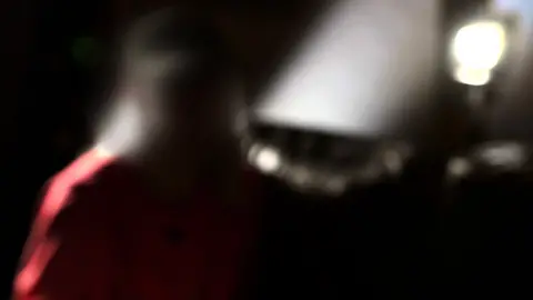 'Violet' is pictured in silhouette, sitting down, with a bright light behind her