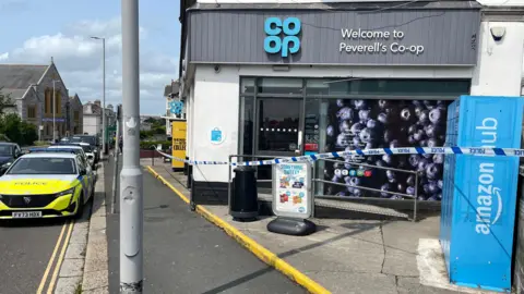 Andy Breare Police vehicle and police tape outside the Peverell Co-op store.