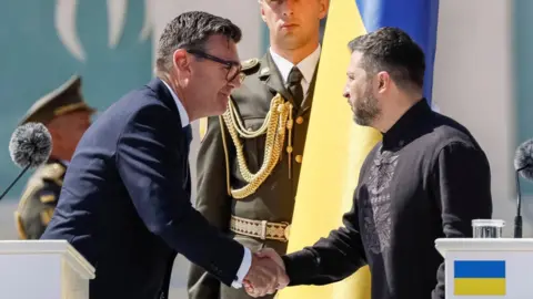 Britain's Prime Minister Andy Burnham greets Ukrainian President Volodymyr Zelenskiy