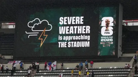 A sign displays 'Severe weather is approaching the stadium' at Mexico City's Azteca Stadium
